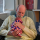 Volunteer cuddler John Myers holds Story at Winchester Medical Center.